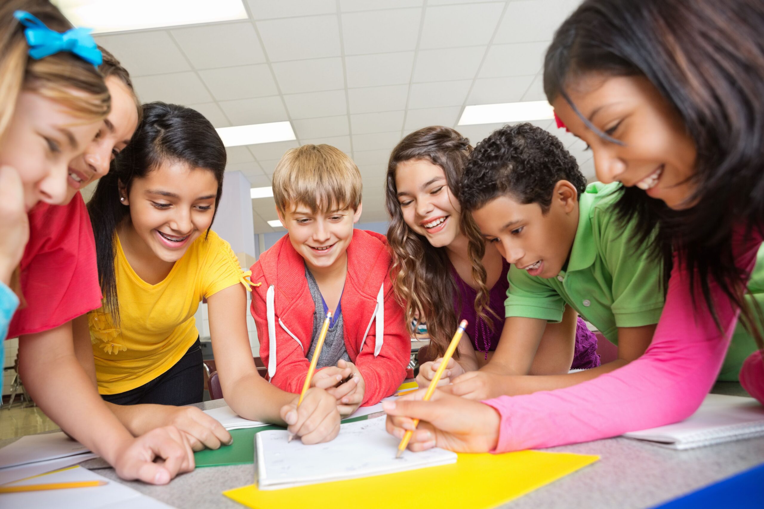 Group of students around a table writing