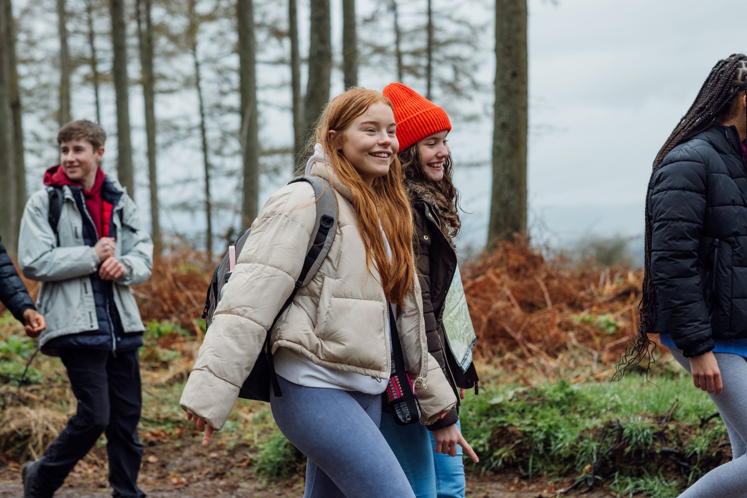 Group of students walking in a wooded area